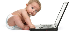 Surprised baby boy using a laptop computer
